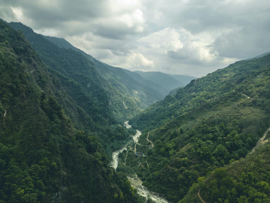 Breathtaking view of lush mountainous valley and river in Ghandruk, perfect for nature lovers and trekkers.