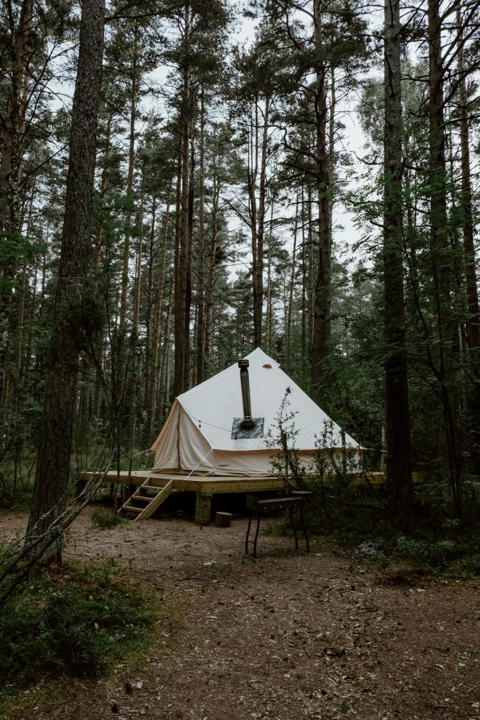 Cozy glamping tent set amidst a serene forest, ideal for relaxation and nature escape.