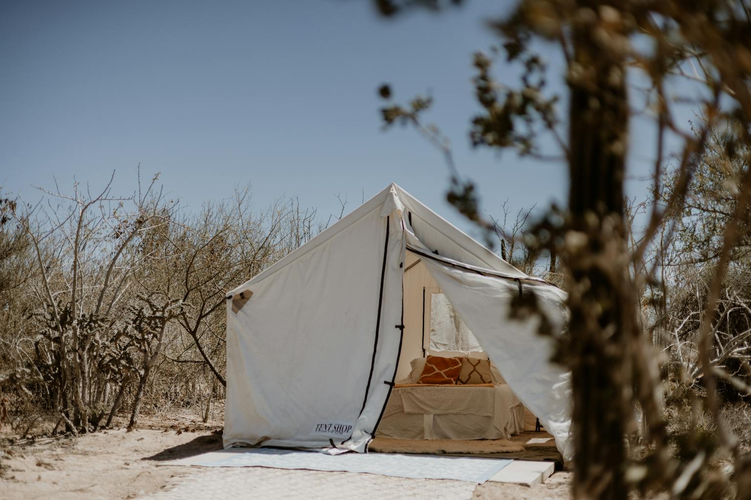 A serene glamping tent setup in a dry desert environment, ideal for adventure travelers.
