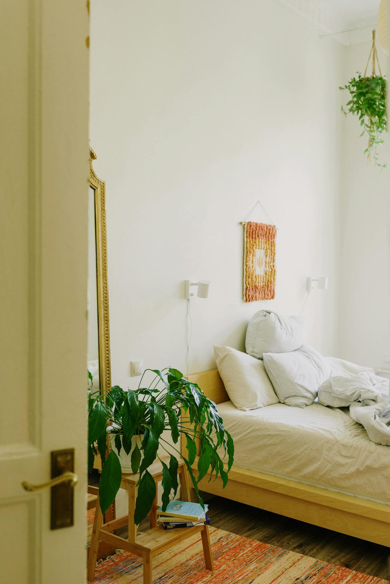 Inviting minimalist bedroom featuring cozy decor and lush indoor plants.
